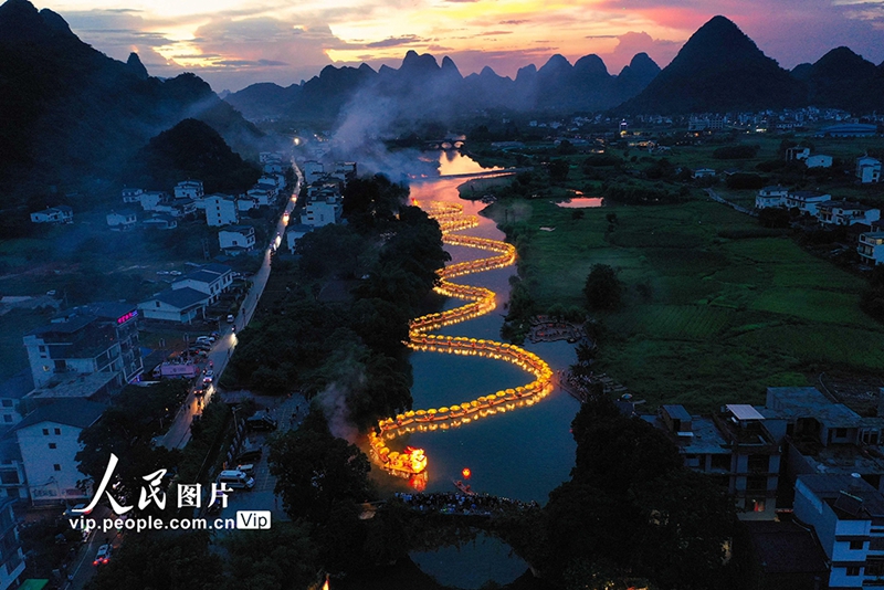 Seekor "naga gergasi" yang terdiri daripada rakit buluh dibuat untuk menyambut Perayaan Perahu Naga yang akan datang. (foto: Li Zhongbo/People.cn)