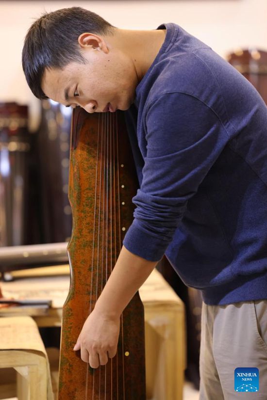 Pembuat Guqin, Xu Yachong sedang menala Guqin di kaunti Lankao, Kaifeng, provinsi Henan, bahagian tengah China pada 9 Oktober 2023. (Xinhua/Xing Guangli)