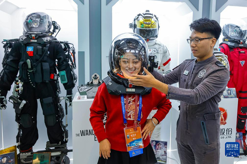 Peminat fiksyen sains mencuba topi keledar yang dibuat pada skala 1:1 berdasarkan filem “The Wandering Earth” pada Pameran Fiksyen Sains Dunia Chengdu 2023 pada 18 Oktober. (Xinhua/Shen Bohan)