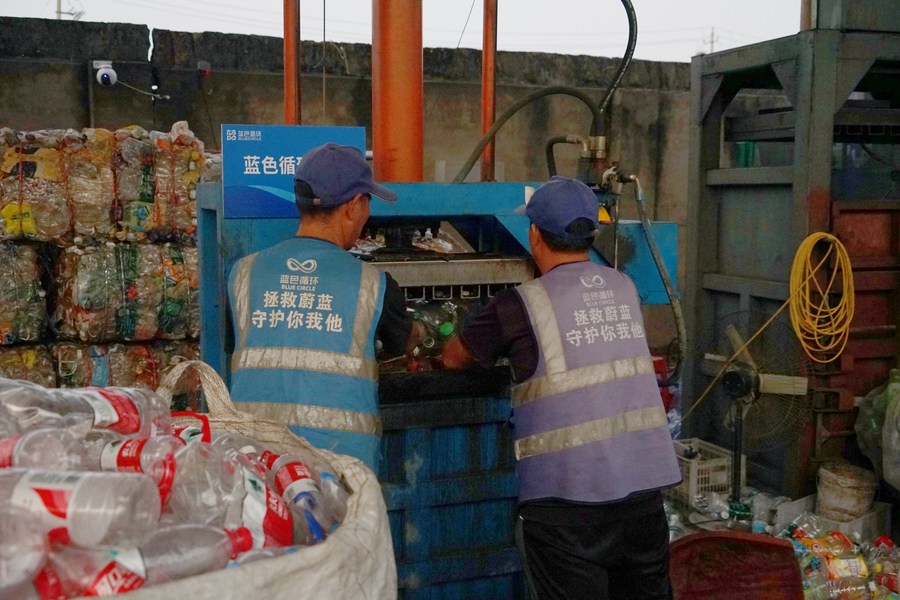 Pekerja memampatkan botol-botol plastik yang telah diisih di sebuah “Rumah Biru Kecil” di daerah Jiaojiang, bandar Taizhou, provinsi Zhejiang, timur China, 17 Oktober 2023. (Xinhua/Lin Guangyao)