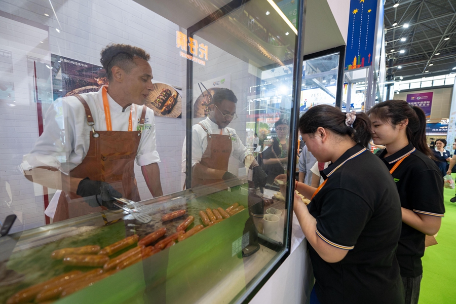 Pengunjung beratur untuk mencuba sosej daging lembu dari Uruguay. (People’s Daily Online/Weng Qiyu)