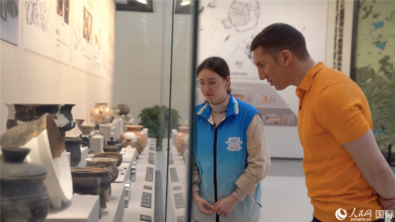 Emma Chen (kiri), tutor sukarelawan dwibahasa di Muzium Liangzhu di Hangzhou, Provinsi Zhejiang, timur China, sedang memberikan penerangan pameran kepada pelawat asing. (People’s Daily Online/Yuan Meng)