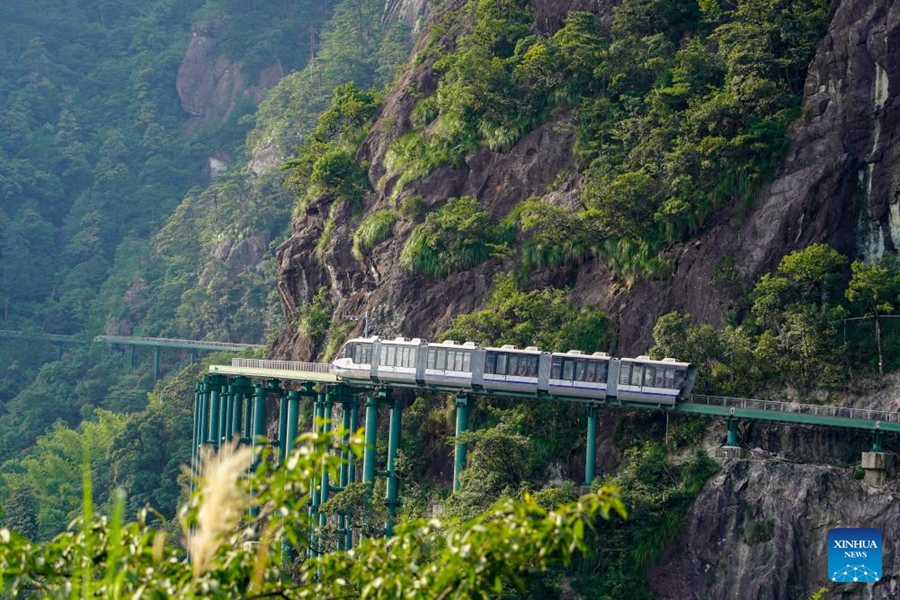 Sebuah kereta api unit berbilang elektrik (EMU) bergerak di Kawasan Pemandangan Gunung Dajue di Wilayah Jiangxi, timur China, 11 Julai 2024. 30 kereta api unit berbilang elektrik (EMU), yang turut digelar ‘persiaran monorel bertingkat kawasan gunung kereta api dan sistem landasan,’ telah dihantar ke Kawasan Pemandangan Gunung Dajue di Kaunti Zixi, Provinsi Jiangxi di timur China, pada Khamis. Dengan lebih satu pertiga daripada laluan jelajah sepanjang 11.8 kilometer di sepanjang tebing, kereta api "menggantung" pengguna di udara pada ketinggian antara 850 dan 1,150 meter. Setakat ini, ia merupakan laluan kereta api tebing yang paling lama di China. (Xinhua/Guo Jiewen)