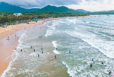 Pelancong meluncur di Teluk Riyue di bandar Wanning, Provinsi Hainan di selatan China. (Foto Meng Zhongde)