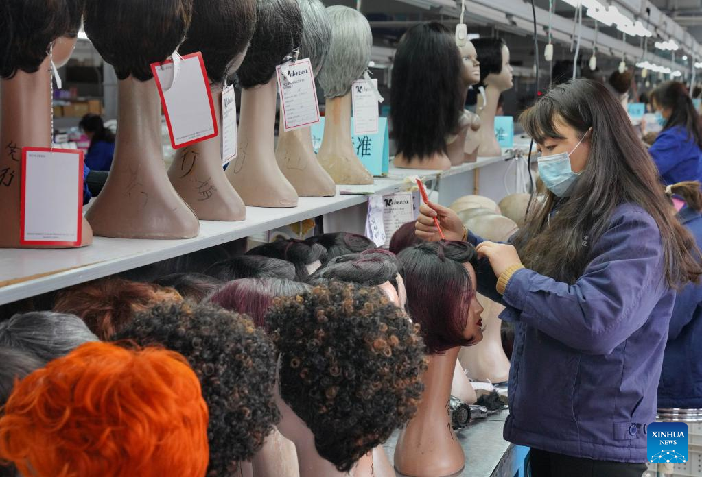 Seorang pekerja membuat rambut palsu di sebuah bengkel milik Henan Rebecca Hair Products di Xuchang, provinsi Henan, tengah China, 16 Mac 2023. (Xinhua/Li An)