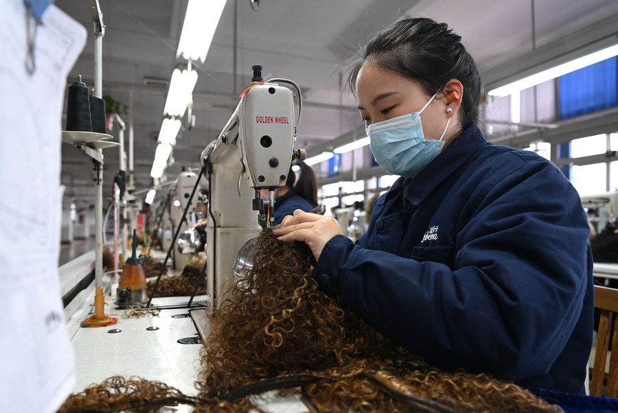 Seorang pekerja membuat rambut palsu di sebuah bengkel milik Henan Rebecca Hair Products di Xuchang, provinsi Henan, tengah China, 16 Mac 2023. (Xinhua/Li An)